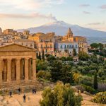 Temple de la Concorde à Agrigente, Sicile, ville historique, mer Méditerranée et Mont Etna fumant au loin, au coucher du soleil.