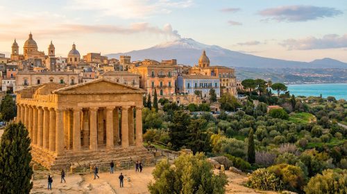 Temple de la Concorde à Agrigente, Sicile, ville historique, mer Méditerranée et Mont Etna fumant au loin, au coucher du soleil.